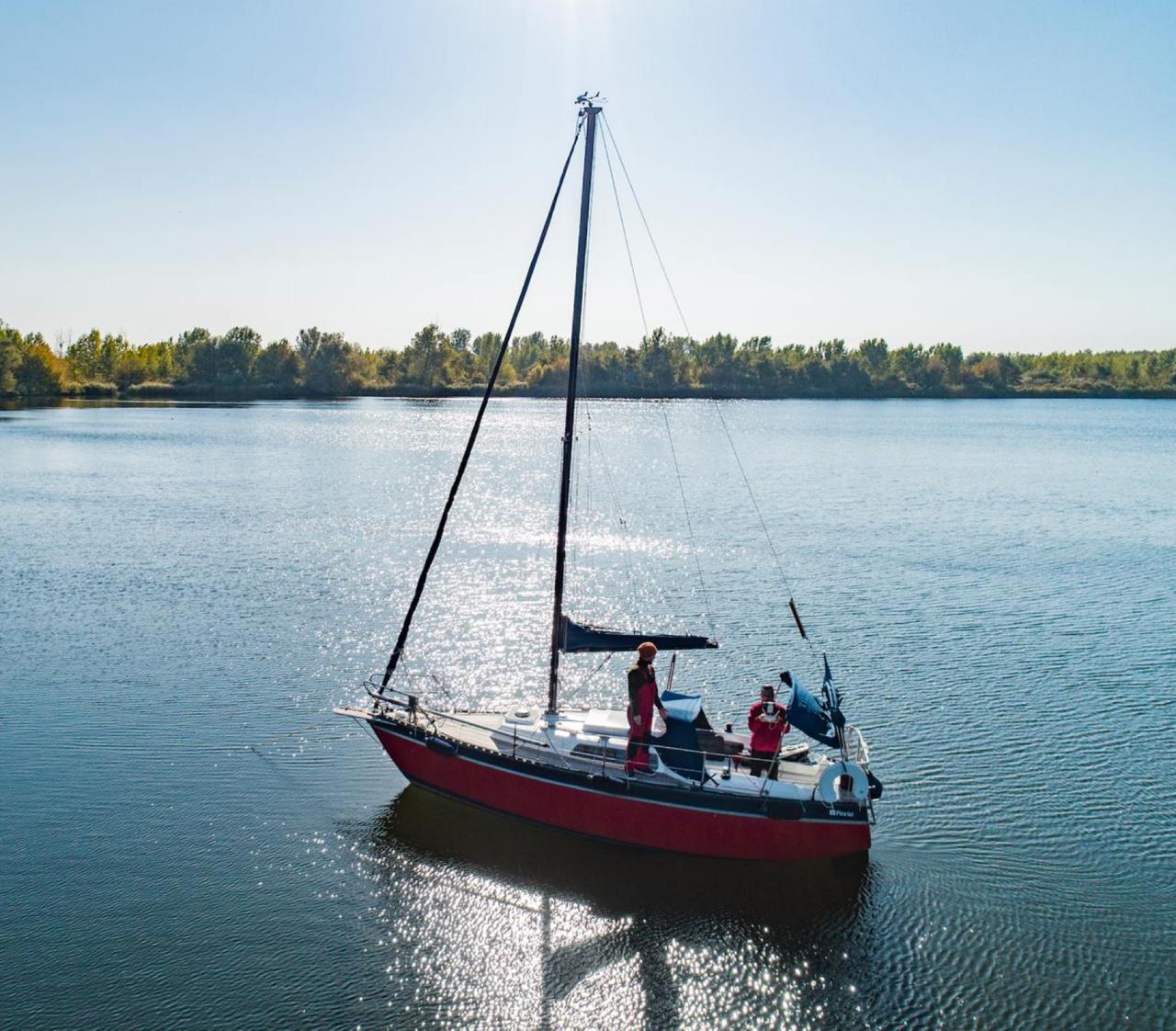 Вітрильний човен Westenwind з червоним корпусом на спокійній воді